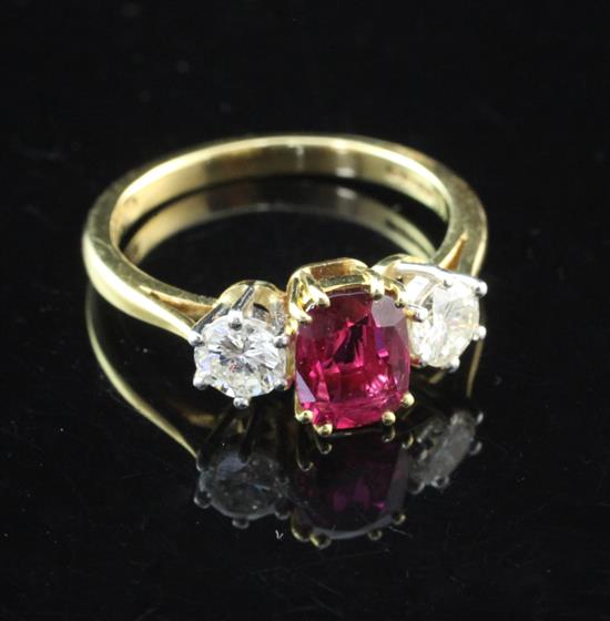 An 18ct gold, three stone ruby and diamond ring, size L.